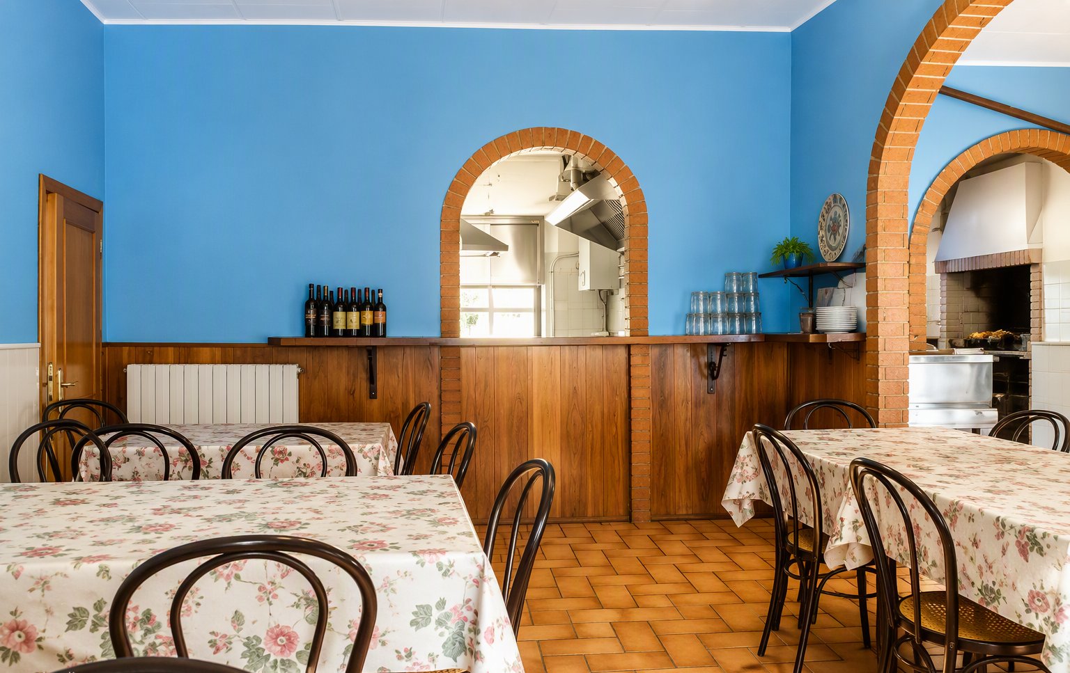 La sala con le pareti azzurre e gli archi in mattoni